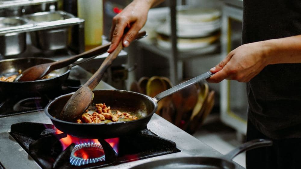 Chef plating a dish on a restaurant kitchen line